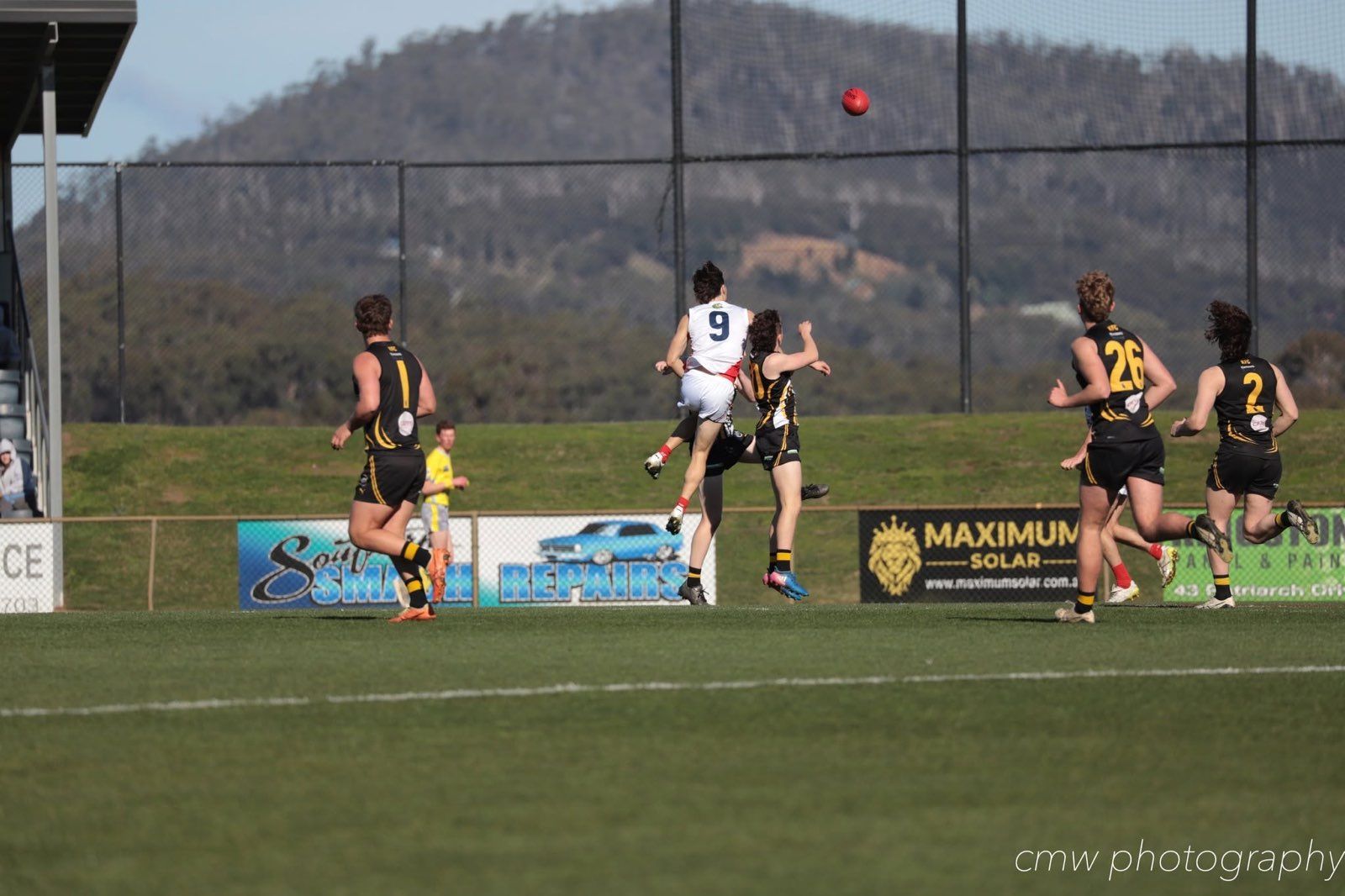 A football match in play with a Maximum Solar sign on the boundary fence