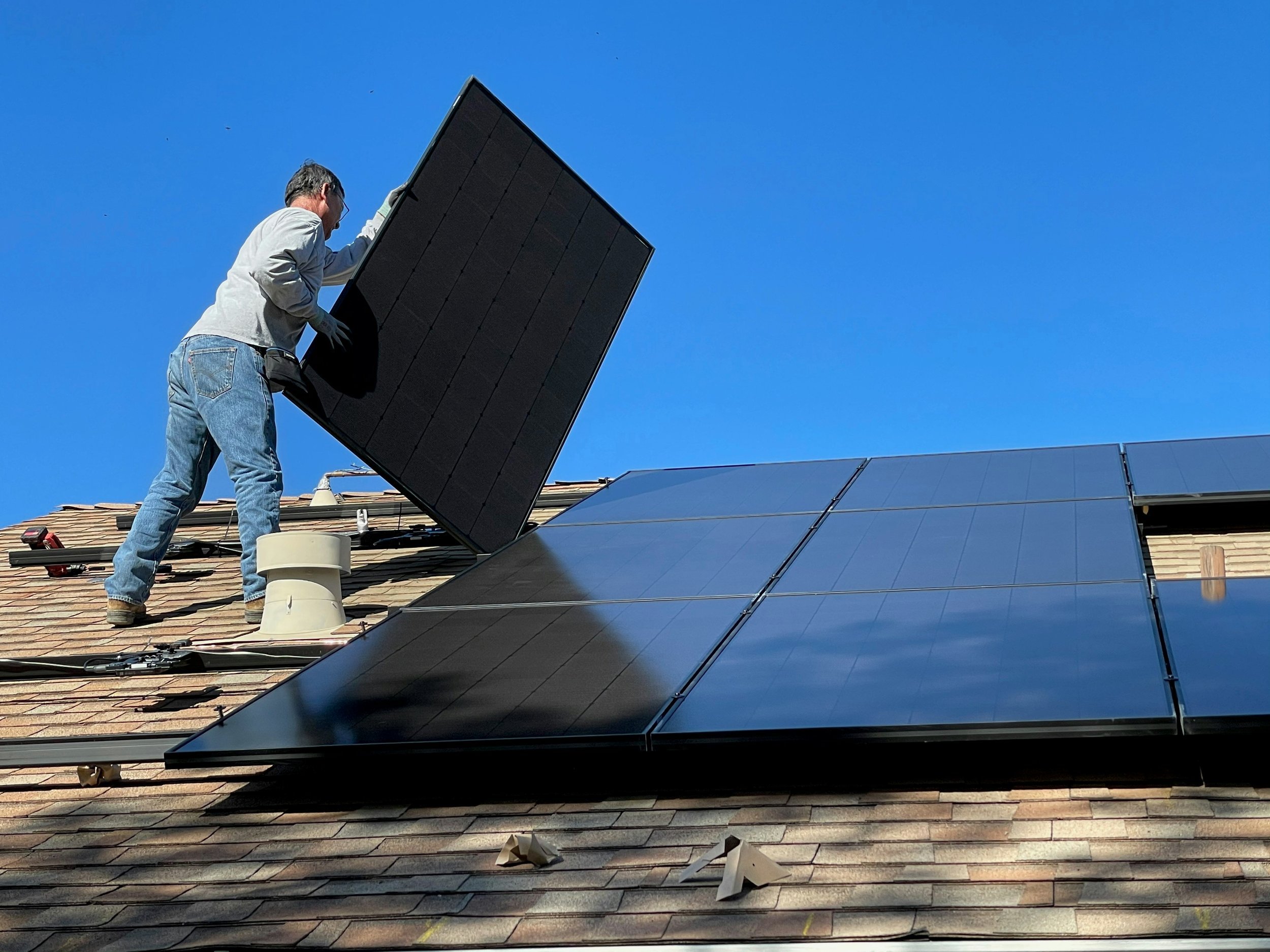 Man installing solar panels on roof